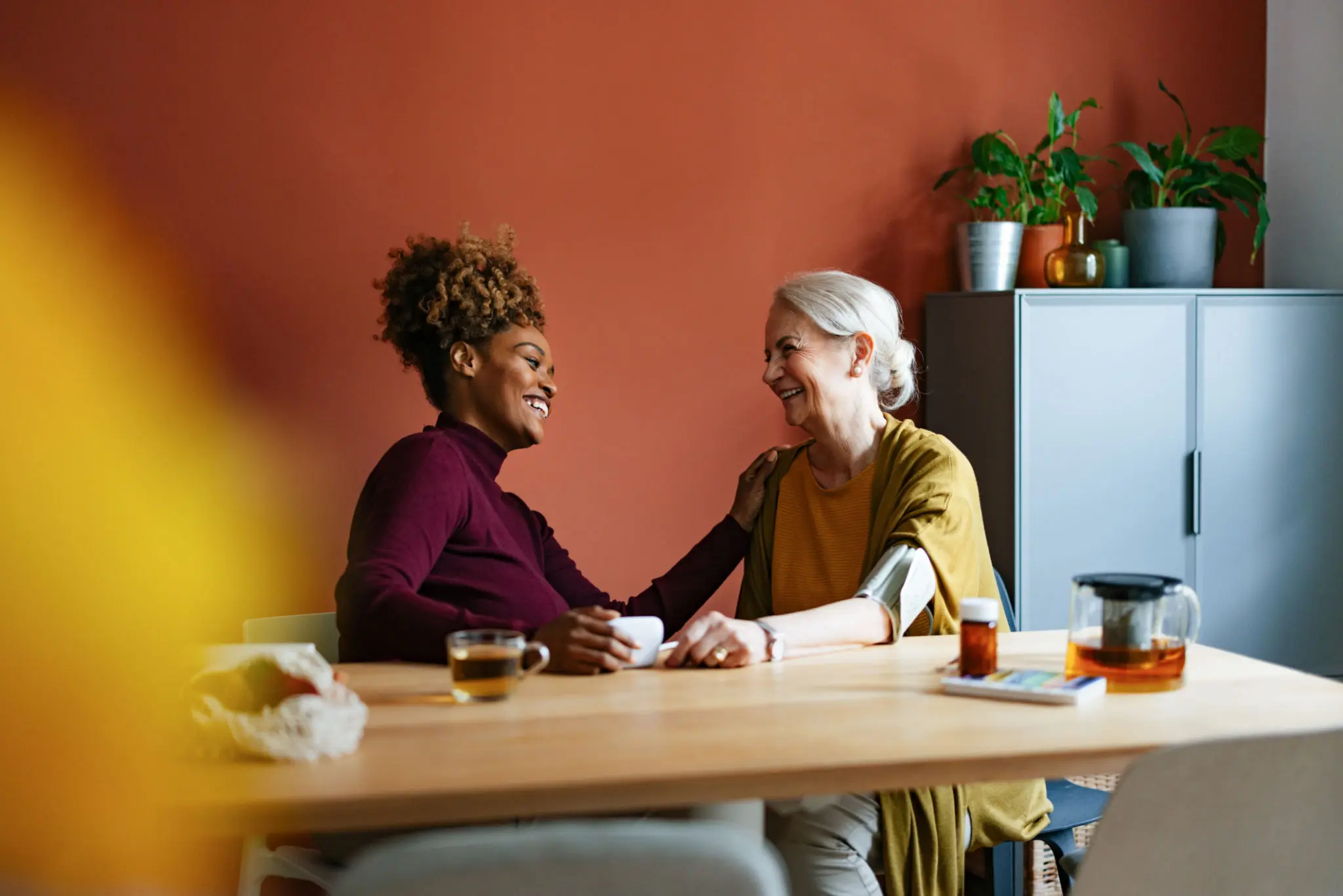 Two women laughing at a table together.